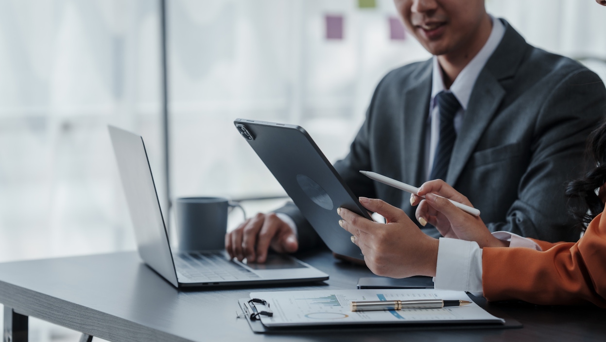 Office working environment showing two colleagues analysing data